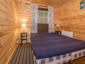 - une chambre avec un lit dans une cabane en bois dans l'établissement Holiday Home Kuusela by Interhome, à Somerniemi