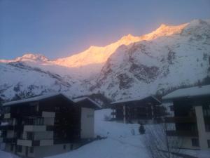a snow covered mountain with a building in the foreground at Apartment La Montanara by Interhome in Saas-Fee