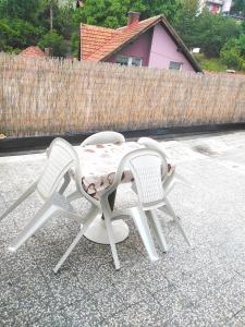 two chairs and a table on a patio at Dvosoban stan in Užice