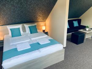 a bedroom with a large bed with blue pillows at Thermal Apartman in Makó