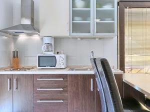 kuchnia z drewnianymi szafkami i mikrofalówką w obiekcie Apartment Villa Alpa-1 by Interhome w mieście Umag