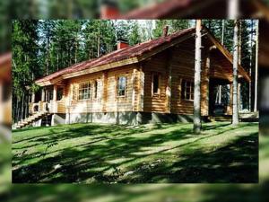 una cabaña de madera en medio de un campo de césped en Holiday Home Männikkö by Interhome en Kammola