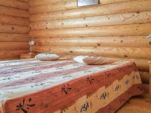 ein Schlafzimmer mit einem Bett in einer Blockhütte in der Unterkunft Holiday Home Männikkö by Interhome in Kammola