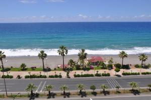 a road with palm trees and the beach at Cebeci Apartments - Extrahome in Mahmutlar