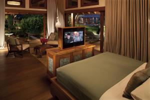 a bedroom with a tv on top of a bed at Howie's HomeStay in Mae Rim