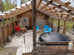 eine große Außenterrasse mit einem Whirlpool und Stühlen in der Unterkunft Holiday Home Eemeli by Interhome in Puomila