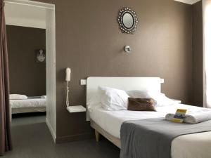 a hotel room with two beds and a mirror at Crystal Hotel in Royan