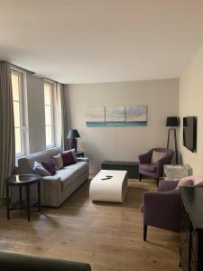 una sala de estar con un sofá y una mesa en Appartement Versailles quartier Notre Dame au pied du Chateau avec Parking, en Versalles