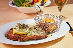 a plate of food with a piece of fish with a lemon at Jagdschloss Windenhütte in Thale