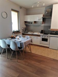 uma cozinha com mesa e cadeiras num quarto em Apartament DobraNocka em Poronin