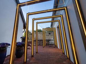a hallway with gold framed mirrors on a building at Platán Udvarház - Platán Tata in Tata