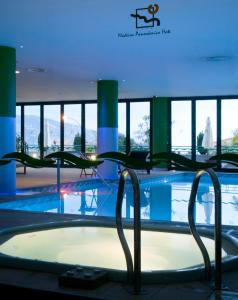 uma piscina com uma banheira de hidromassagem num edifício em Madeira Panorâmico Hotel no Funchal