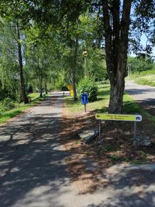 una señal en el lado de un camino junto a un árbol en Chalet village vacances en Waulsort
