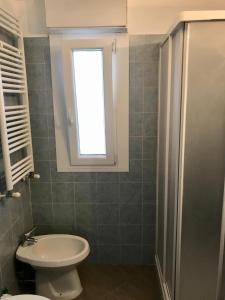 a bathroom with a toilet and a window at Aquarius Rome Apartments in Mostacciano