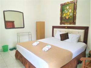 En eller flere senge i et værelse på Hotel Perdana