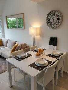 une salle à manger avec une table et une horloge au mur dans l'établissement TERRASSES DE MALMEDY - Duplex "HAPPINESS" - Pellet & Airco-, à Malmedy