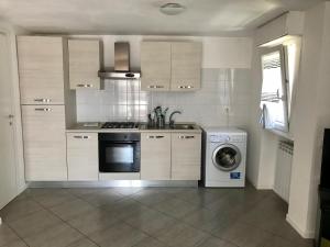 a kitchen with a stove and a washing machine at Aquarius Rome Apartments in Mostacciano