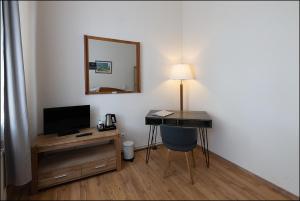 a room with a desk with a television and a mirror at MARKT EINS Gästezimmer in Schöppenstedt
