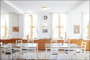 a dining room with white tables and white chairs at MARKT EINS Gästezimmer in Schöppenstedt