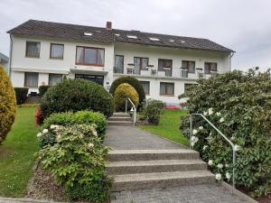 ein weißes Haus mit einer Treppe davor in der Unterkunft Haus Leifert in Bad Sassendorf