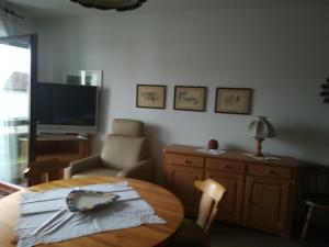a living room with a table and a tv at Ferienwohnung Ziegelbergblick in Jockgrim