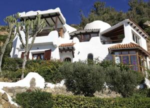 una gran casa blanca con árboles delante de ella en Chalet El Encanto en Zahara de los Atunes