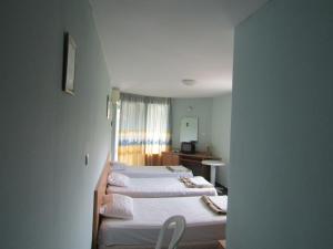 Zimmer mit 2 Betten, einem Schreibtisch und einem Spiegel in der Unterkunft Hostel Papagal in Warna