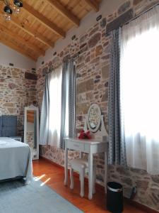 a bedroom with a table and a stone wall at Castro Rooms Chios in Chios