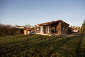 a small house sitting on top of a grass field at LES CHALETS D HERMINE in Montredon-Labessonnié