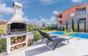 a patio with a stone fireplace next to a pool at Sun & Sea Villa in Krk