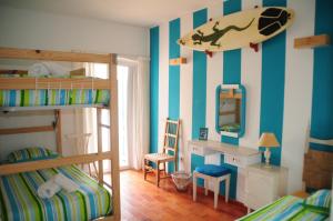 a bedroom with bunk beds with a surfboard on the wall at Jho'La Surf Camp in Luz