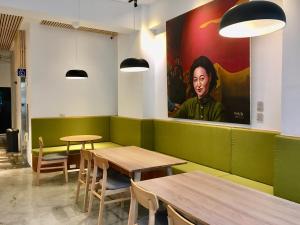 a restaurant with tables and a large painting on the wall at 良文旅 Ryou Hotel Tainan in Tainan