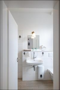 Baño blanco con lavabo y espejo en MARKT EINS Gästezimmer, en Schöppenstedt