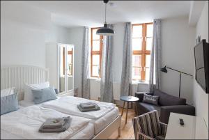 a white bedroom with a bed and a couch at MARKT EINS Gästezimmer in Schöppenstedt