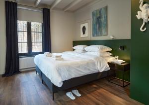 a bedroom with a large bed with white sheets and pillows at The Guest Apartments - Uilenburg in Den Bosch