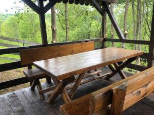 ein hölzerner Picknicktisch und Bänke auf einer Terrasse in der Unterkunft Conacul Secaria in Secăria
