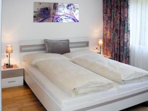 1 cama blanca en un dormitorio con 2 lámparas en Apartment Eberharter - MHO153 by Interhome en Mayrhofen