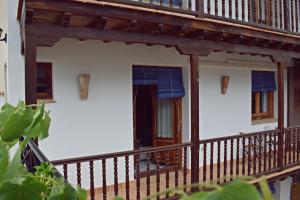 balcón de una casa con barandilla de madera en Apartamentos Turisticos La vida de antes, en Consuegra