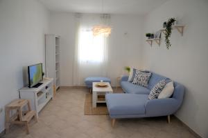 a living room with a blue couch and a tv at Casa di Felicita in Biograd na Moru