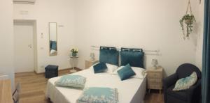 - une chambre avec un lit doté d'oreillers bleus et d'une chaise dans l'établissement Ostia Lido Central Rooms, à Lido di Ostia