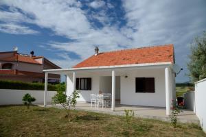 a white house with a table and chairs at Casa di Felicita in Biograd na Moru