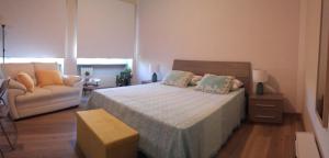 1 dormitorio con 1 cama grande y 1 sofá en Lido Centro B&B, en Lido di Ostia