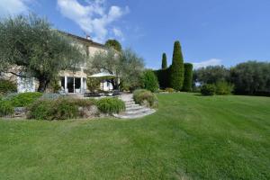 a house with a green yard with a grass field at Clos Notre Dame in Mouans-Sartoux