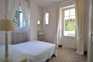 a white bedroom with a bed and a window at Clos Notre Dame in Mouans-Sartoux