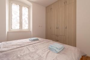 ein Schlafzimmer mit einem Bett mit zwei Handtüchern darauf in der Unterkunft Apartment Kira in Split