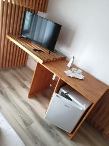 a desk with a television and a refrigerator under it at Motel Mesterul Manole in Curtea de Argeş +11 photos