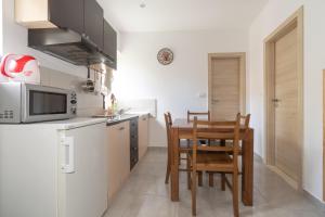 eine Küche mit einem Tisch, Stühlen und einer Mikrowelle in der Unterkunft Apartment Kira in Split