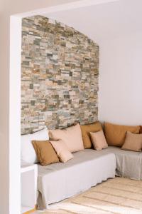 a living room with a couch against a brick wall at Apartaments Cap Sa Sal in Begur
