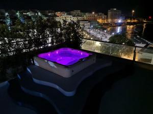 bañera de color púrpura en el balcón por la noche en Relais La Pretura, en Vieste