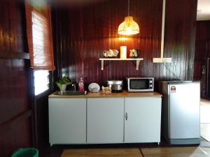 a kitchen with a counter with a microwave and a refrigerator at Rumah Rehat Anjung Melayu Muslim in Melaka